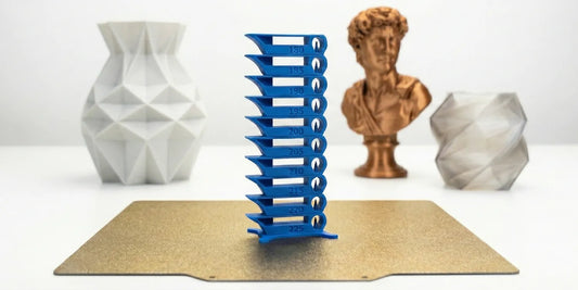 A 3D printed temperature tower standing on a PEI build plate.
